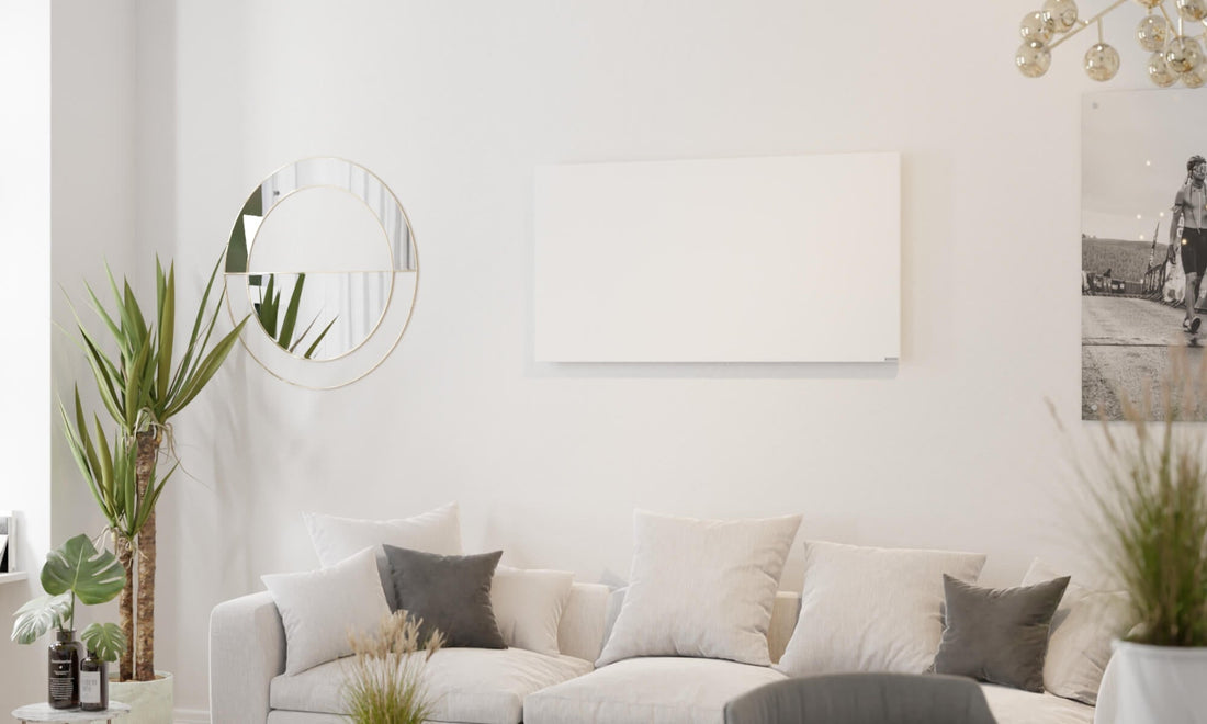 woonkamer met bank, planten en infraroodpaneel aan de muur