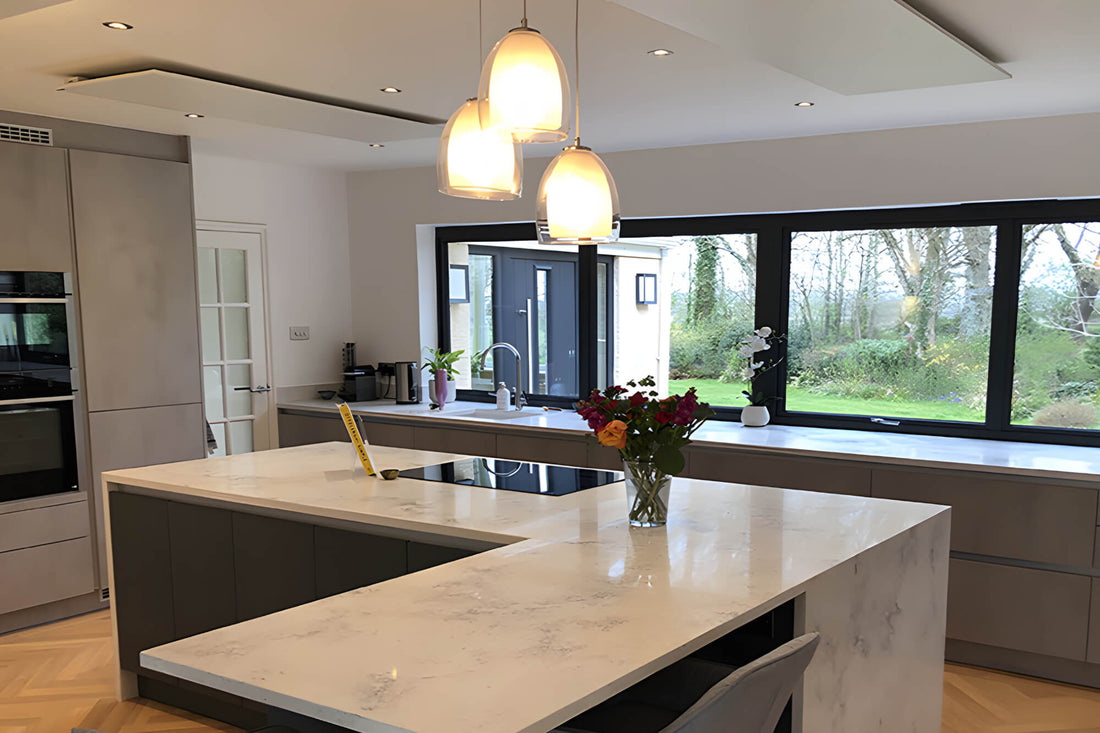 moderne keuken met kookeiland en infraroodpanelen tegen het plafond bij groot raam