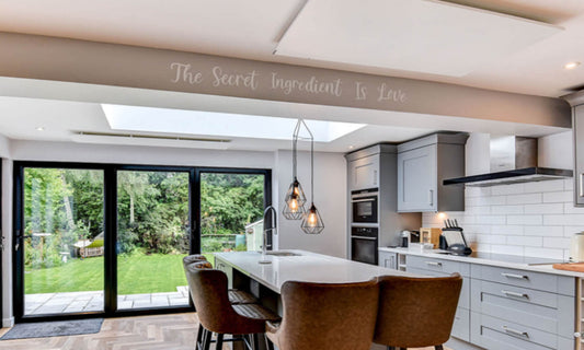 moderne keuken met kookeiland en twee infraroodpanelen op het plafond en zicht op tuin
