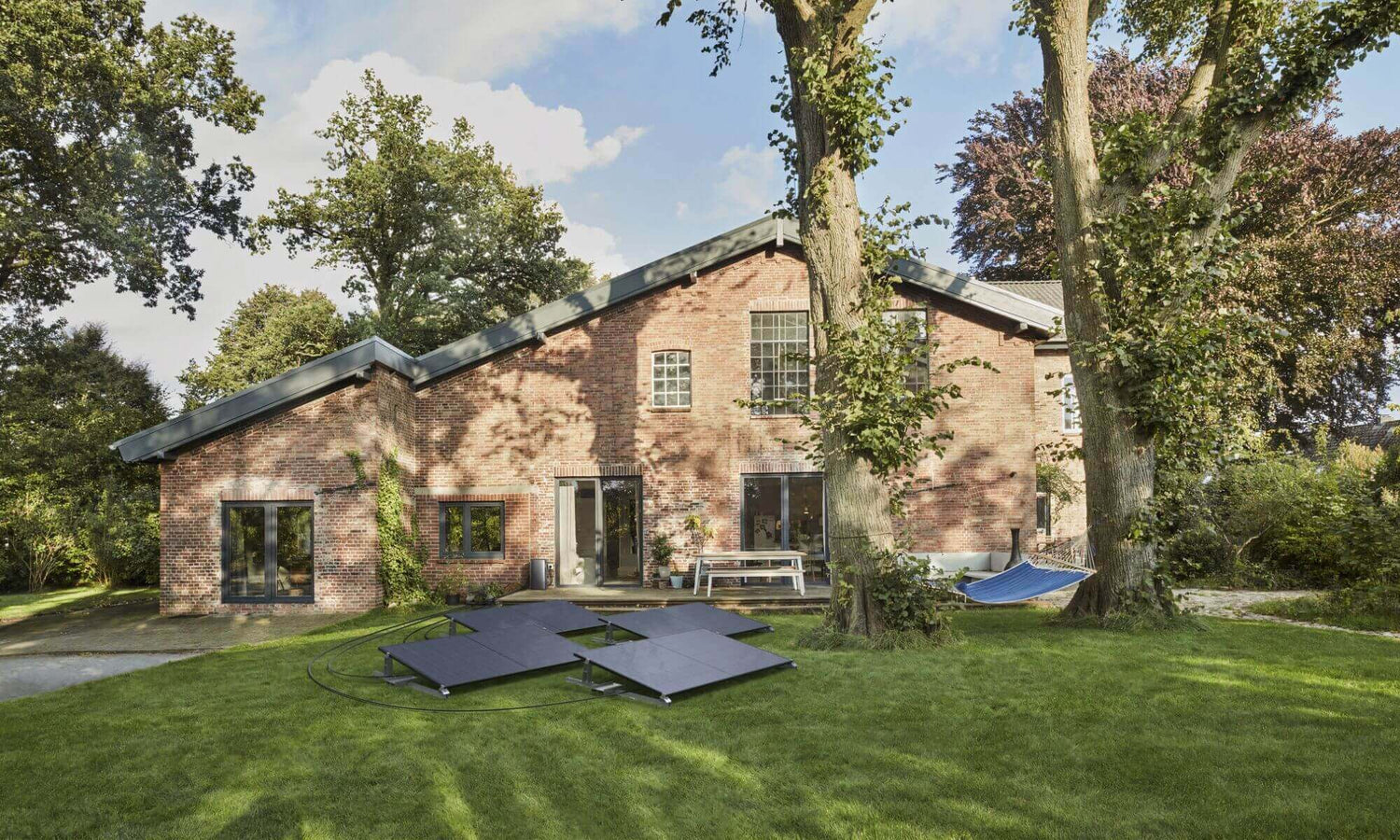 Woning met EcoFlow STREAM Ultra thuisbatterij en aangesloten zonnepanelen in de tuin