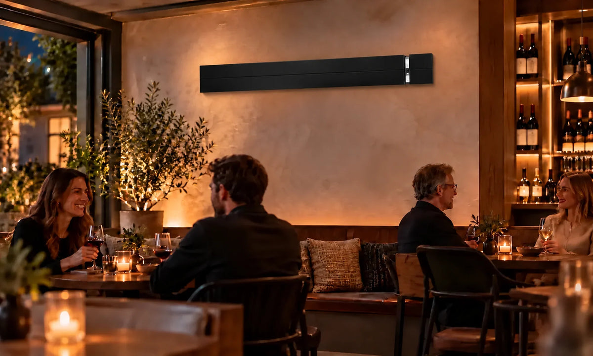 Zwarte Herschel SUMMIT 2600 W infraroodstraler hoog aan de muur in een wijnbar