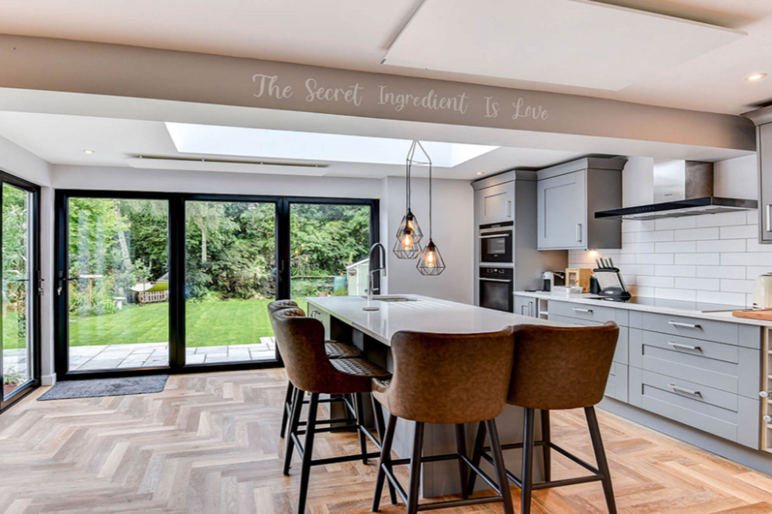 Moderne keuken, grote glasdeuren naar de tuin en twee witte infraroodpanelen op het plafond.