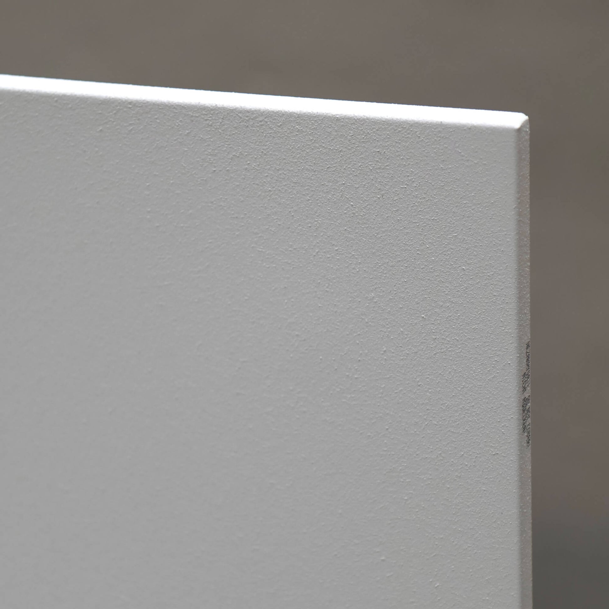 Close-up van wit Nova infrarood verwarmingspaneel met zichtbare fijne oppervlaktestructuur