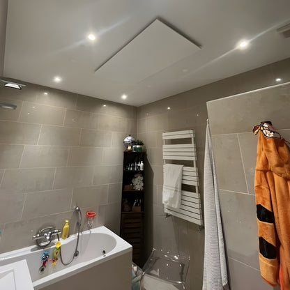 Wit Nova infrarood verwarmingspaneel gemonteerd aan het plafond in een badkamer