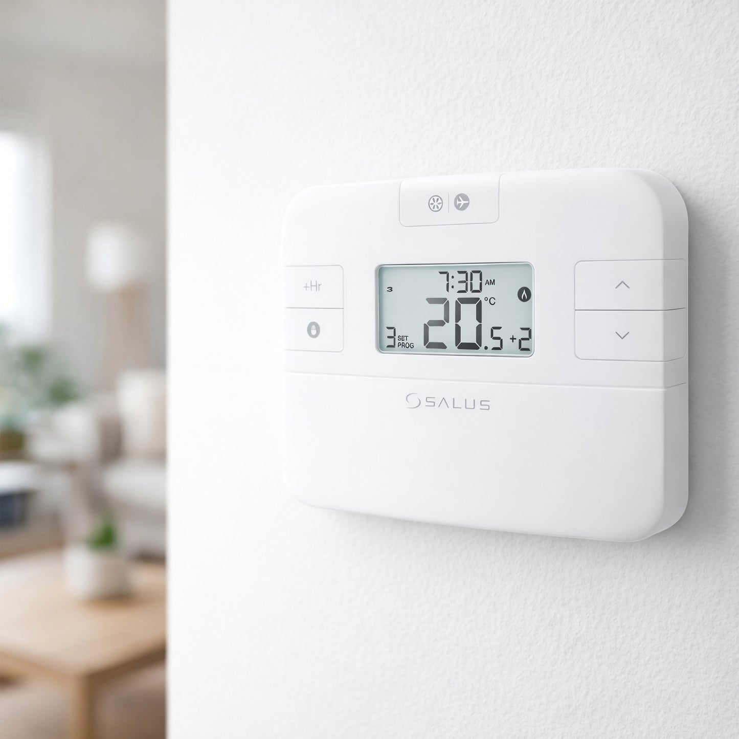 Witte Salus draadloze thermostaat met digitaal display gemonteerd op een witte muur met onscherpe woonruimte op de achtergrond